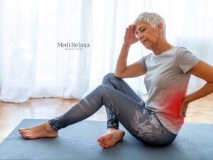 mujer en ropa deportiva en la estera de yoga con 10 ejercicios para el dolor de espalda baja