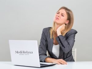 mujer con dolor de cuello en el escritorio