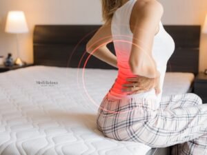 mujer en cama con dolor de espalda después de dormir
