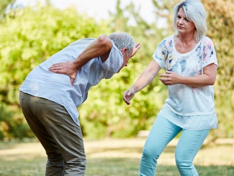 Mujer ayudando a hombre con síntomas de lumbago