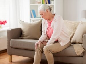 mujer sentada con dolor muscular en la pierna