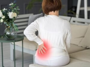 mujer sentada con dolor persistente espalda baja mujer