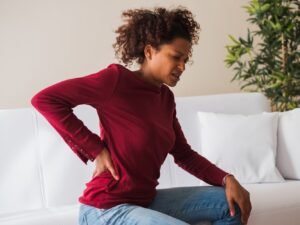 mujer en el asiento con dolor muscular y articular en todas partes