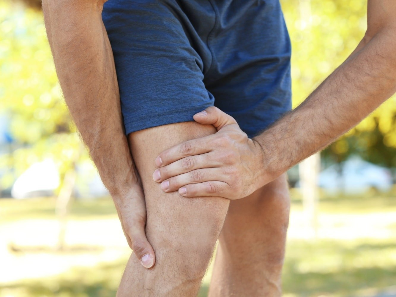 man die grijpt naar pijnlijke benen