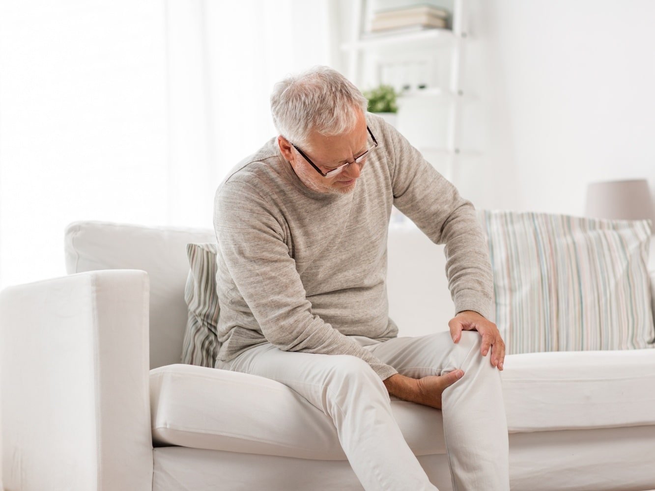 man met Spierreuma symptomen in de zetel